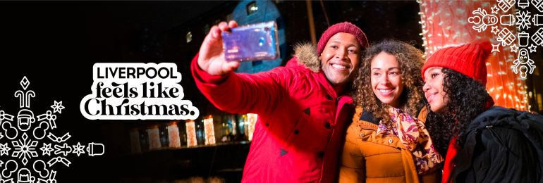 A family of three take a selfie at the Albert Dock at Christmas