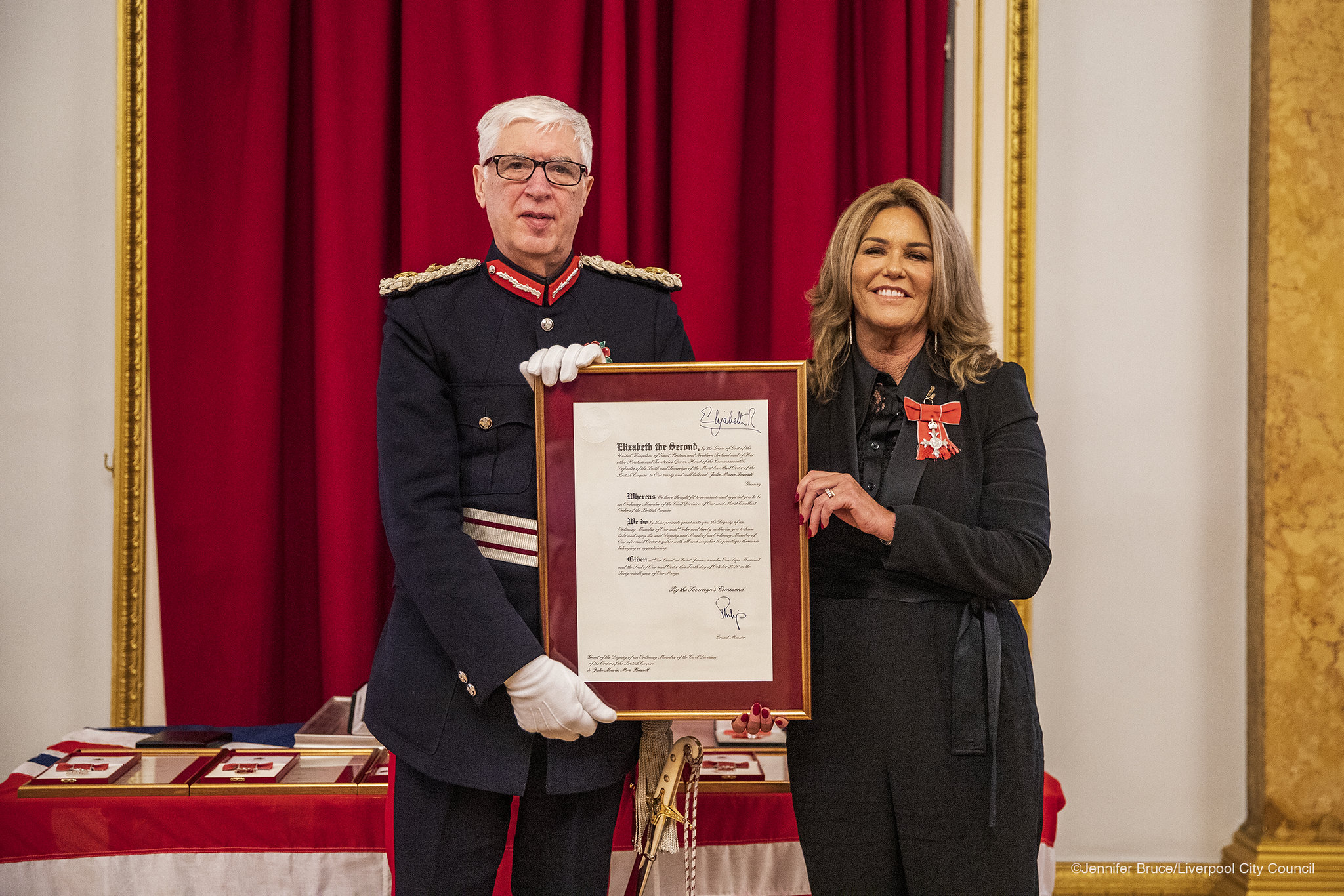 Mark Blundell, Lord-Lieutenant of Merseyside presents Julie Cashin with her MBE.