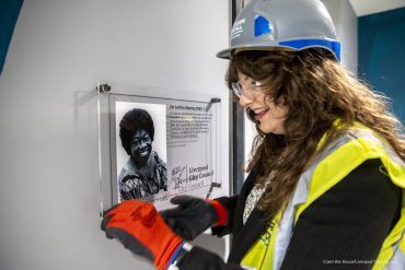 Cllr Sarah Doyle fixes a plaque to a wall at the Liverpool Novotel