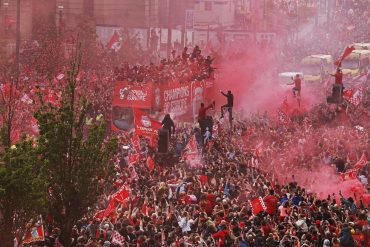 LFC fans line homecoming parade route on The Strand with the LFC 'Champions of Europe' bus in the centre. It's a sea of red.