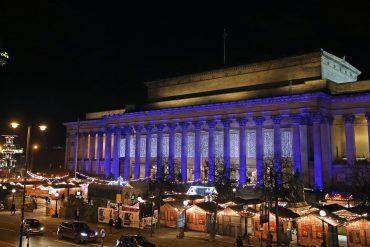 Night image of St George's Hall with Christmas market stalls on the plateau