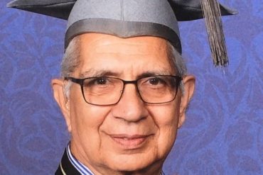 A man wearing n academic gown and mortar board