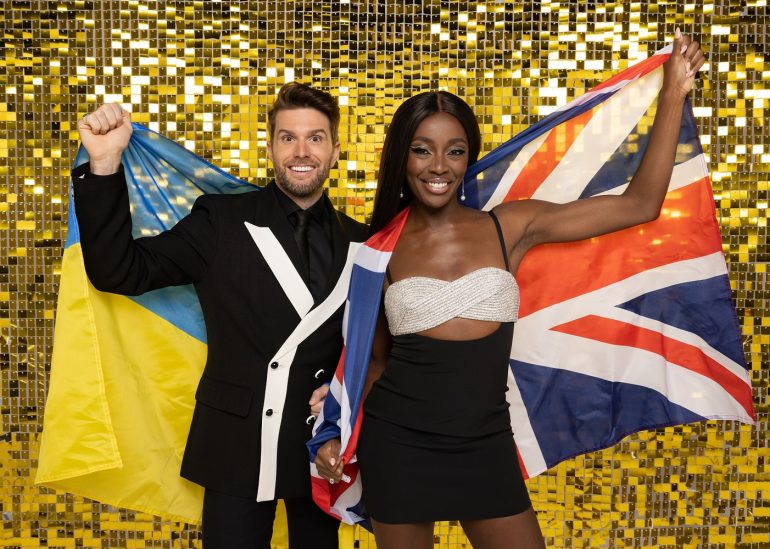 Eurovision Big Welcome hosts Joel Dommett holding a Ukraine flag and AJ Odudu holding a Union Jack flag