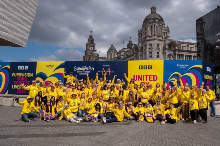 A group of Eurovision volunteers cheering at the Pier Head