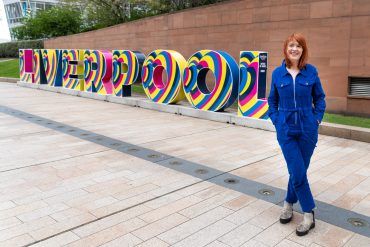 Director of Culture Liverpool, Claire McColgan standing in front of a Liverpool sign.