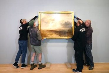 Tate Liverpool staff taking a painting off a wall