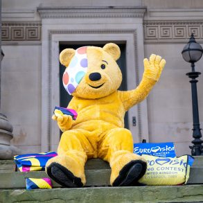 Pudsey sat on the steps of St George's Hall surrounded by Eurovision merchandise