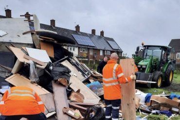 Collection crews remove fly-tipped waste at an illegal bonfire site in Liverpool