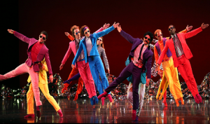 Dancers in colourful outfits on stage.