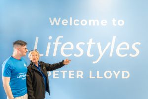 Two people stood in front of Lifestyles branding