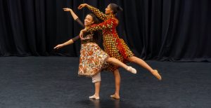 A vibrant image shows a group of diverse people embracing each other, with smiles and laughter. In the centre is an older man with grey hair and a beard, joyfully interacting with others. The background is blurred, indicating an outdoor setting. To the right is a logo with colourful shapes and text that reads "ALL TOGETHER INSPIRED." Below the image is a tagline stating, "Working together to build a fairer, healthier Cheshire and Merseyside." A pink banner at the top left contains the phrase "Helpful information for stakeholders."
