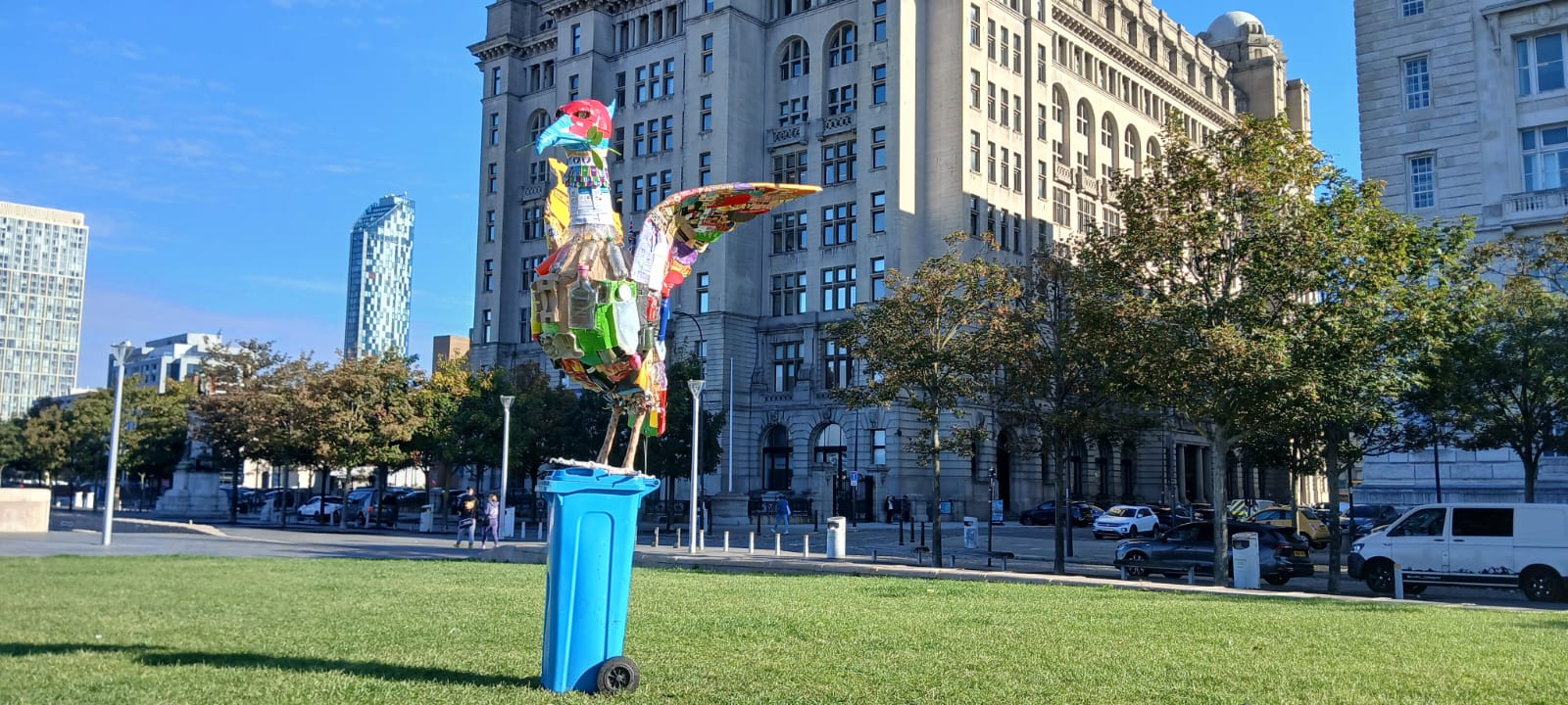 The "Third Liver Bird" standing proudly in front of the Liver Building on a sunny day.