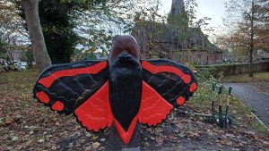 A wooden sculpture of a moth