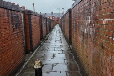 A thin walkway that has been cleared of rubbish.