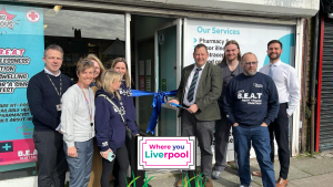 A group of people stood outside the BEAT Pharmacy with Matt Ashton about to cut the ribbon