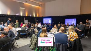 Groups of people sat in a conference hall.