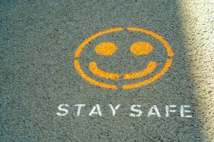 Yellow smiley face with text underneath that reads 'Stay Safe'