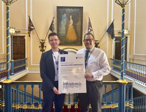 Harry Doyle and Matt Ashton stood holding a placard in the Town Hall