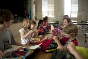 Children eating lunch out of lunch boxes