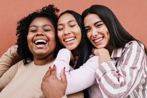 Three women hugging and smiling